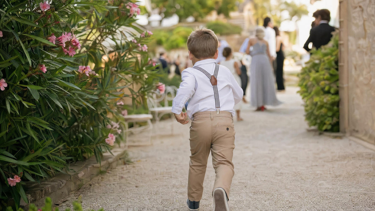 Enfant portant des bretelles pour une cérémonie, tenue élégante et naturelle. Obraz